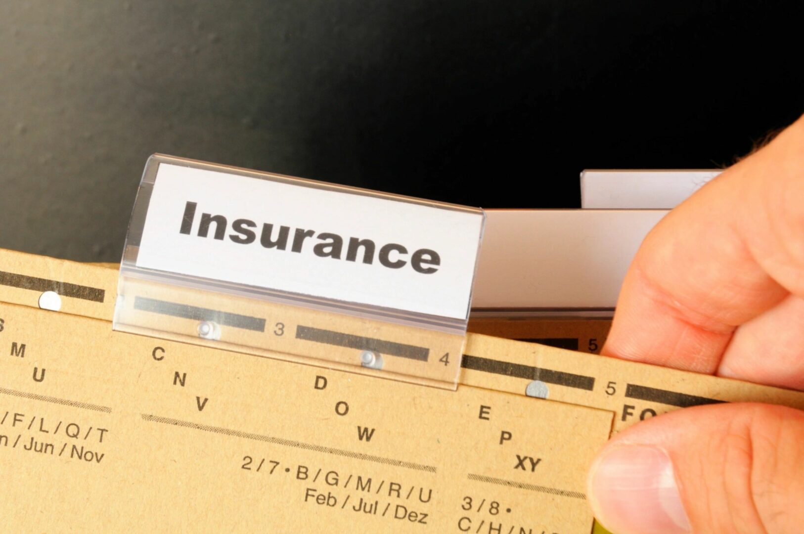 A person is holding an insurance card in their hand.